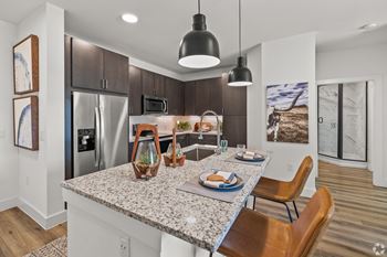 A modern kitchen with a granite countertop and stainless steel appliances. at Aurora Watson Branch, Texas, 76063